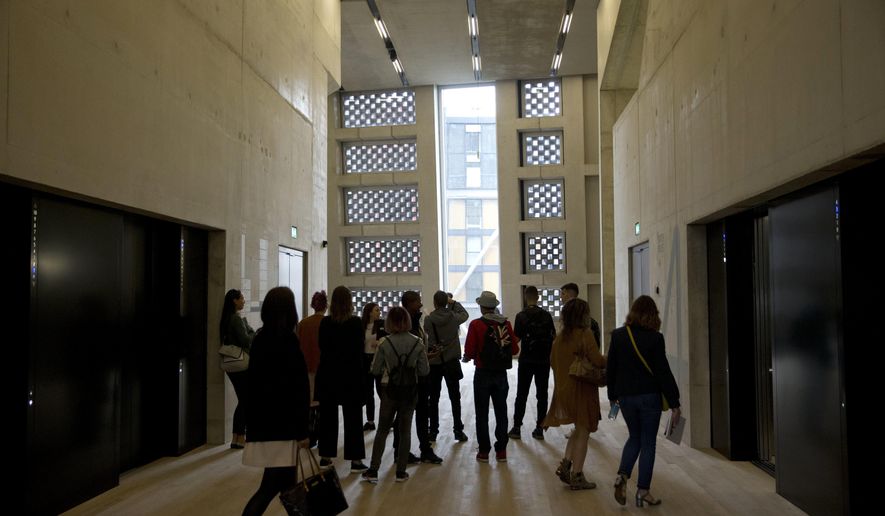 FILE - In this Tuesday, June 14, 2016 file photo, people stand in an area by the lifts in the new Switch House building extension to the Tate Modern gallery in London. On Tuesday Feb. 12, 2019, neighbors of London's Tate Modern lost a legal fight to force the art gallery to close a viewing platform that gives visitors a view into their homes. (AP Photo/Matt Dunham, file)