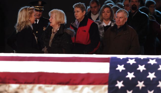 Rep. Debbie Dingell, D-Mich., left, greets the public at the casket of her husband, former Rep. John Dingell, lying in repose in Dearborn, Mich., Monday, Feb. 11, 2019. John Dingell, the longest-serving member of Congress in American history, was first elected in 1955 and retired in 2014. The Democrat was 92. (AP Photo/Paul Sancya)