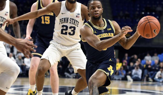 Michigan guard Zavier Simpson (3) passes the ball as Penn State guard Josh Reaves (23) defends during the first half of an NCAA college basketball game, Tuesday, Feb. 12, 2019, in State College, Pa. (AP Photo/John Beale)