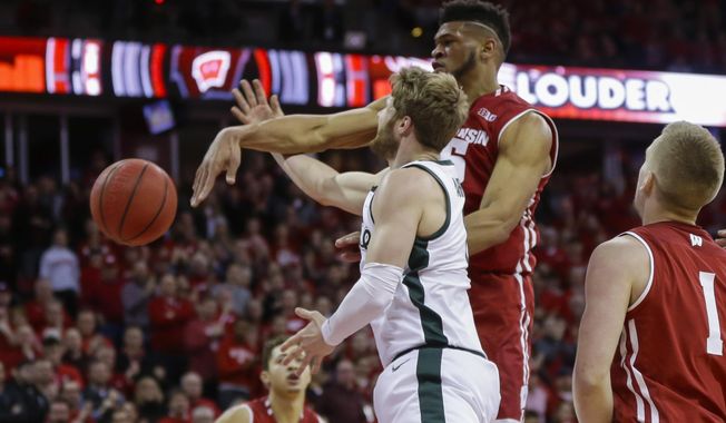 Wisconsin's Charles Thomas (15) blocks a a shot by Michigan States's Kyle Ahrens (0) during the first half of an NCAA college basketball game Tuesday, Feb. 12, 2019, in Madison, Wis. (AP Photo/Andy Manis)