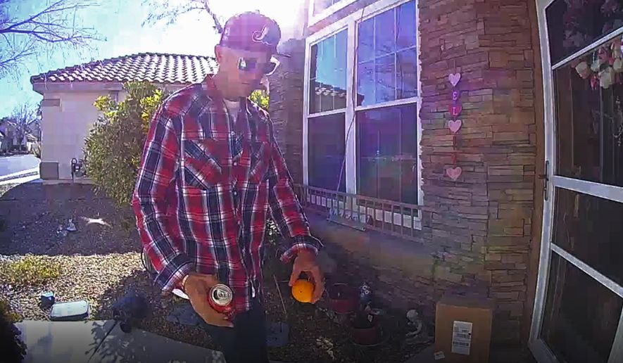 This photo released Tuesday, Feb. 12, 2019, by the Las Vegas Metropolitan Police Department shows a package thief who made off Thursday, Feb. 7, with a delivery box containing what a mother reported was $40,000 worth of cancer treatment drugs for her 14-year-old son. The photo from doorbell security video shows a man wearing sunglasses, a red plaid shirt and a red baseball cap before he took two packages and walked away on Thursday. (Las Vegas Metropolitan Police Department via AP)