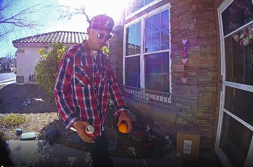 This photo released Tuesday, Feb. 12, 2019, by the Las Vegas Metropolitan Police Department shows a package thief who made off Thursday, Feb. 7, with a delivery box containing what a mother reported was $40,000 worth of cancer treatment drugs for her 14-year-old son. The photo from doorbell security video shows a man wearing sunglasses, a red plaid shirt and a red baseball cap before he took two packages and walked away on Thursday. (Las Vegas Metropolitan Police Department via AP)