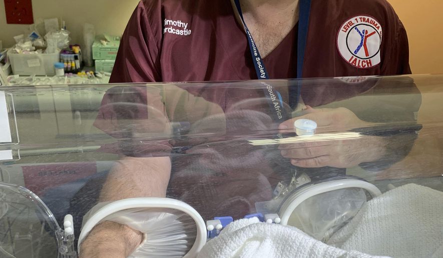Doctor Timothy Hardcastle treats a baby in hospital after she was rescued from a storm water pipe in Durban, South Africa, Monday, Feb. 11, 2019. The newborn, believed to be between one and three days old, was rescued after a three-hour rescue mission. (AP Photo)