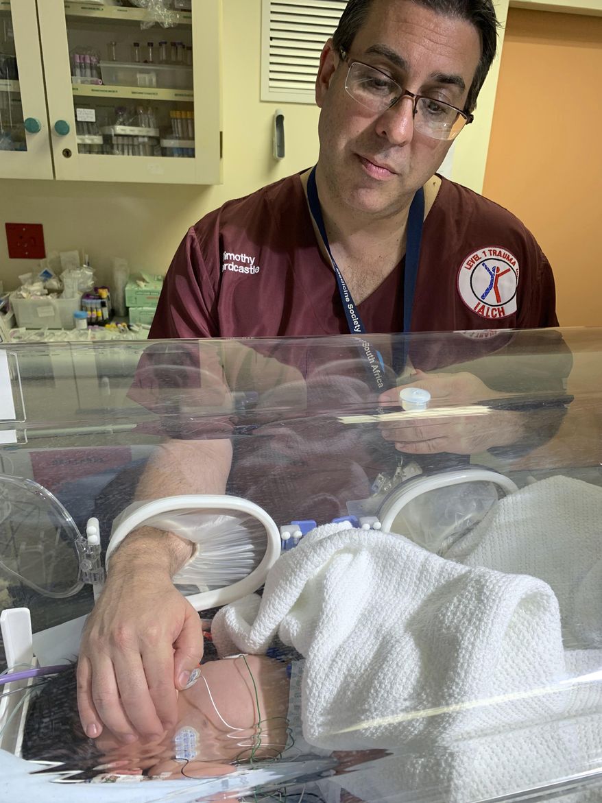 Doctor Timothy Hardcastle treats a baby in hospital after she was rescued from a storm water pipe in Durban, South Africa, Monday, Feb. 11, 2019. The newborn, believed to be between one and three days old, was rescued after a three-hour rescue mission. (AP Photo)