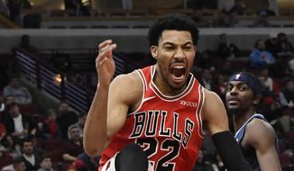 Chicago Bulls forward Otto Porter Jr. (22) reacts after dunking the ball against the Chicago Bulls as Memphis Grizzlies forward Justin Holiday (7) stands nearby during the second half of an NBA basketball game, Wednesday, Feb. 13, 2019, in Chicago. The Bulls won 122-110. (AP Photo/David Banks)
