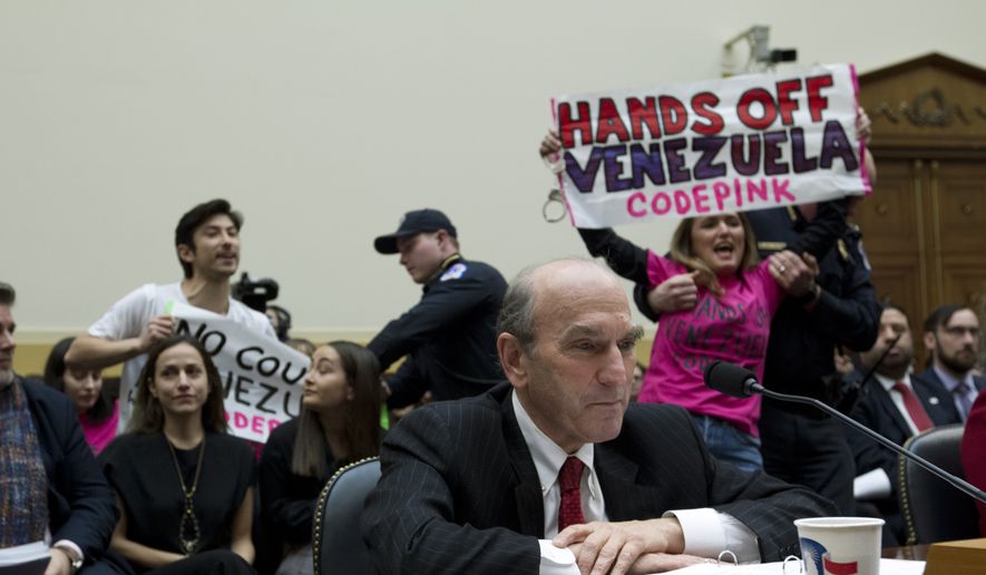 U.S. Special Representative for Venezuela Elliott Abrams testifies as code pink demonstrators protest, during the House Foreign Affairs subcommittee hearing on Venezuela at Capitol Hill in Washington, Wednesday, Feb. 13, 2019. (AP Photo/Jose Luis Magana)