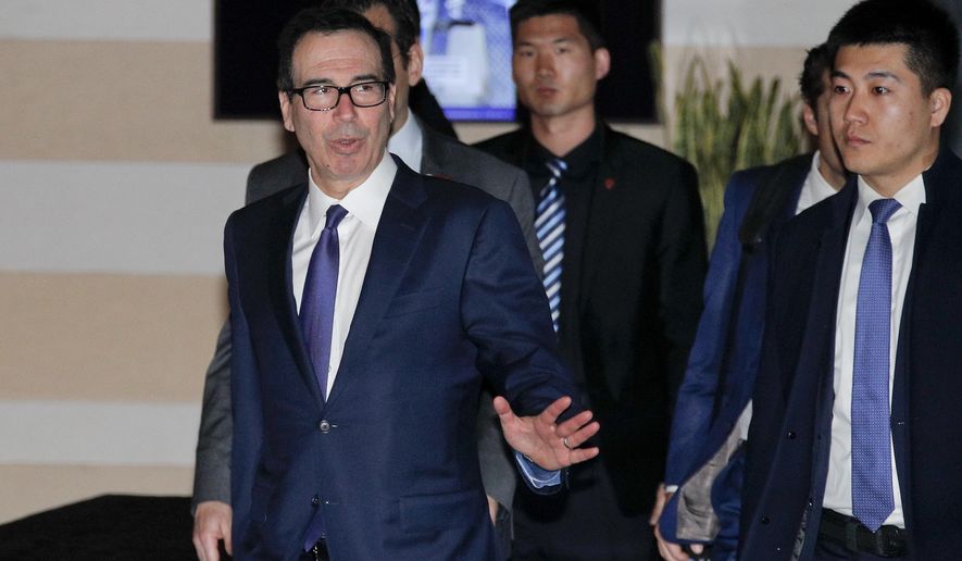 U.S. Treasury Secretary Steven Mnuchin, left, gestures to journalists as he leaves a hotel to attend a new round of high-level trade talks with Chinese officials in Beijing, Thursday, Feb. 14, 2019. (AP Photo/Andy Wong)