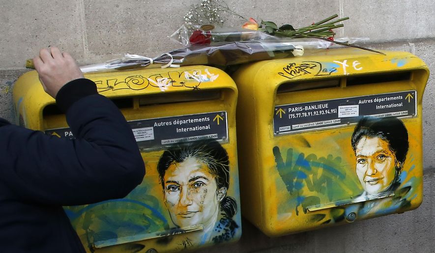 French street artist Christian Guemy, known as C215, cleans the vandalized mailboxes with swastikas covering the face of the late Holocaust survivor and renowned French politician, Simone Veil, in Paris, Tuesday Feb.12, 2019. According to French authorities, the total of registered anti-Semitic acts rose to 541 in 2018 from 311 in 2017, a rise of 74 percent. (AP Photo/Michel Euler)