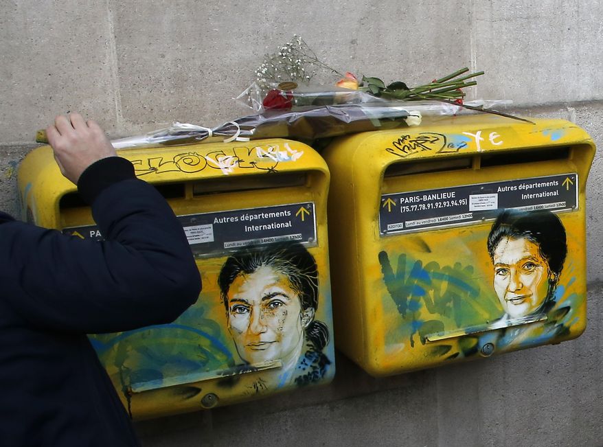 French street artist Christian Guemy, known as C215, cleans the vandalized mailboxes with swastikas covering the face of the late Holocaust survivor and renowned French politician, Simone Veil, in Paris, Tuesday Feb.12, 2019. According to French authorities, the total of registered anti-Semitic acts rose to 541 in 2018 from 311 in 2017, a rise of 74 percent. (AP Photo/Michel Euler)