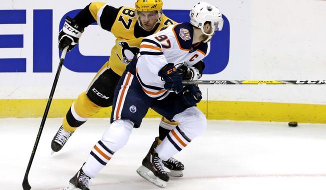 Pittsburgh Penguins&#x27; Sidney Crosby (87) defends against Edmonton Oilers&#x27; Connor McDavid (97) during the first period of an NHL hockey game in Pittsburgh, Wednesday, Feb. 13, 2019. (AP Photo/Gene J. Puskar)