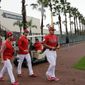Philadelphia Phillies catcher Andrew Knapp, left, starting pitcher Aaron Nola, center, and relief pitcher Victor Arano, right, walk onto the field at the Philadelphia Phillies spring training baseball facility, Wednesday, Feb. 13, 2019, in Clearwater, Fla. (AP Photo/Lynne Sladky)