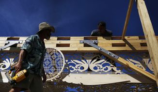 Volunteers help build a California artist, David Best&#39;s vision for a non-denominational, temporary temple for the anniversary of the Marjory Stoneman Douglas High School shooting massacre, on Tuesday, Feb. 5, 2019 in Coral Springs, Fla. The temple will remain open until May when it will be burned in a purification ceremony. (AP Photo/Brynn Anderson)