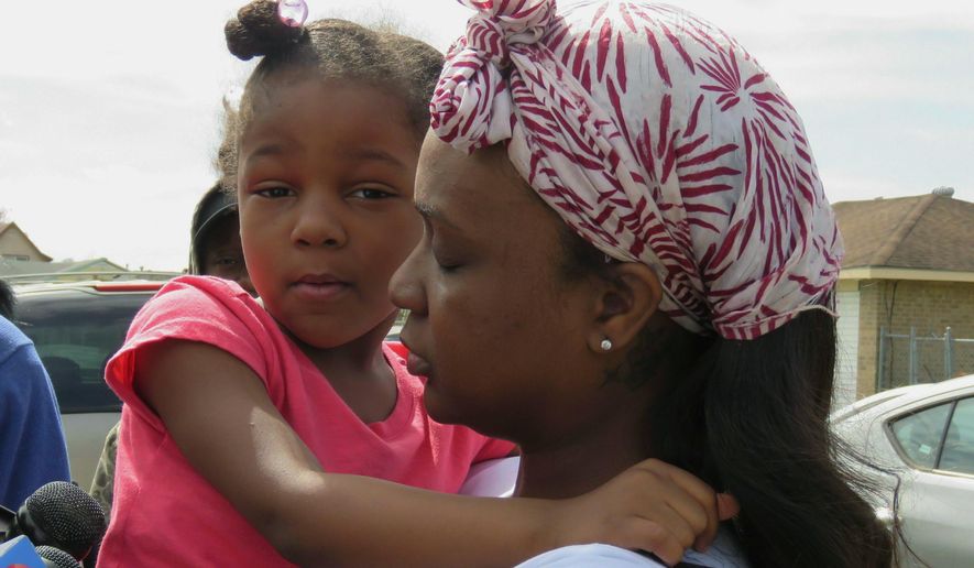 Markia Thomas, of Marrero, La., holds her daughter as she talks to reporters Thursday, Feb. 14, 2019, about the death of her 9-year-old son, Marquis Thomas Jr., the previous night. Marquis was accidentally shot in the head and killed Wednesday night when an 18-year-old cousin tried to get his gun away from the youngster, a Louisiana sheriff said. (AP Photo/Janet McConnaughey)