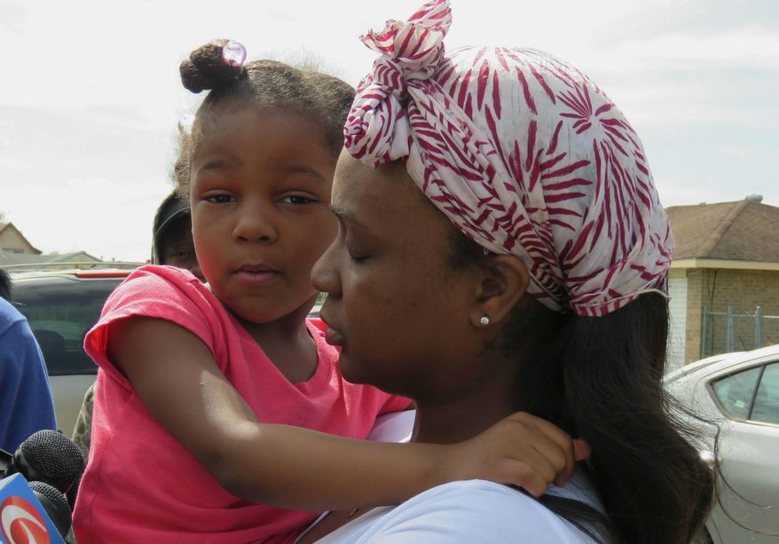 Markia Thomas, of Marrero, La., holds her daughter as she talks to reporters Thursday, Feb. 14, 2019, about the death of her 9-year-old son, Marquis Thomas Jr., the previous night. Marquis was accidentally shot in the head and killed Wednesday night when an 18-year-old cousin tried to get his gun away from the youngster, a Louisiana sheriff said. (AP Photo/Janet McConnaughey)