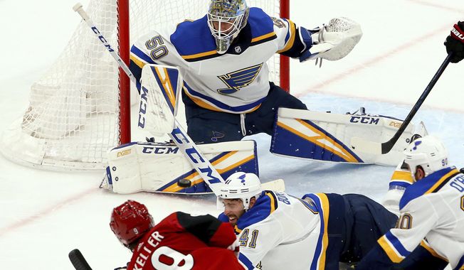 St. Louis Blues goaltender Jordan Binnington (50) makes a save on a shot by Arizona Coyotes center Clayton Keller (9) as Blues defenseman Robert Bortuzzo (41) and center Ryan O&#x27;Reilly (90) try to block the shot during the second period of an NHL hockey game Thursday, Feb. 14, 2019, in Glendale, Ariz. (AP Photo/Ross D. Franklin)
