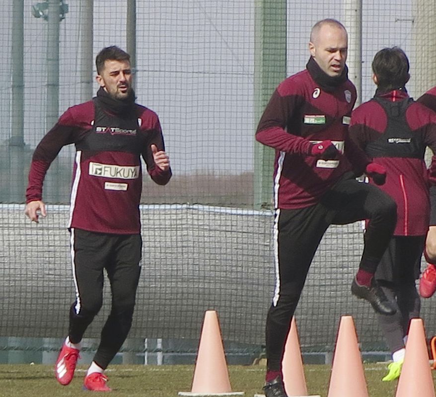 In this Jan. 21, 2019, photo, Vissel Kobe&#x27;s Andres Iniesta, right, and David Villa, left, warm up during their team&#x27;s training in Kobe, western Japan. Iniesta is hoping the addition of former Barcelona teammate Villa will lead to bigger and better things for his Japanese soccer team this season. (Kyodo News via AP)