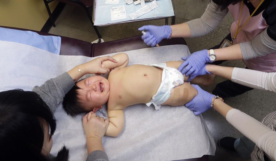 One-year-old Able Zhang cries as he receives the last of three inoculations, including a vaccine for measles, mumps, and rubella (MMR), at the International Community Health Services Wednesday, Feb. 13, 2019, in Seattle. The boy's tears lasted only a few moments after he received the shots. A recent measles outbreak has sickened dozens of people in the Pacific Northwest, most in Washington state and, of those, most are concentrated in Clark County, just north of Portland, Oregon. Washington Gov. Jay Inslee declared a state of emergency over the outbreak last month. (AP Photo/Elaine Thompson)