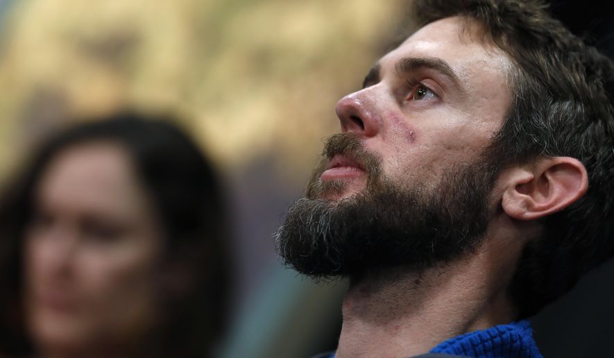 Travis Kauffman responds to questions during a news conference Thursday, Feb. 14, 2019, in Fort Collins, Colo., about his encounter with a mountain lion while running a trail just west of Fort Collins last week. Kaufman's girlfriend, Annie Bierbower, looks on. (AP Photo/David Zalubowski)