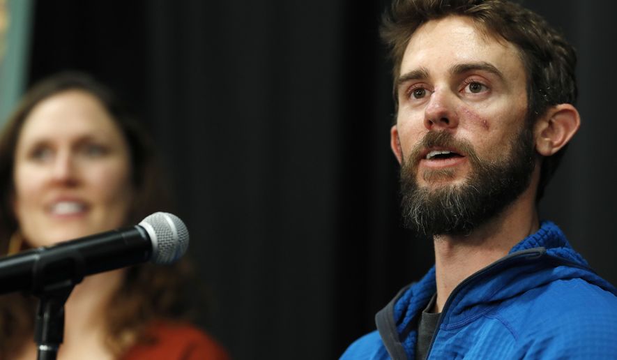 Travis Kauffman responds to questions during a news conference Thursday, Feb. 14, 2019, in Fort Collins, Colo., about his encounter with a mountain lion while running a trail just west of Fort Collins last week. Kaufman's girlfriend, Annie Bierbower, looks on at left. (AP Photo/David Zalubowski)