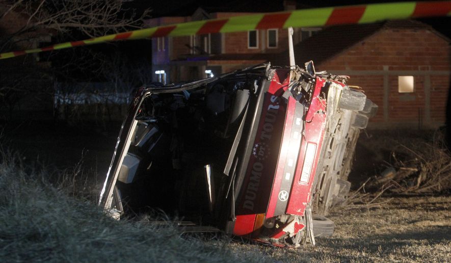 A bus lays at the crash site at village of Laskarci, west of Skopje, North Macedonia, Wednesday, Feb. 13, 2019. Macedonia's health minister says some have died and many are injured in the bus crash, carrying workers on a highway west of the capital, Skopje. (AP Photo/Boris Grdanoski)