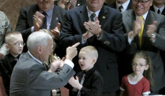 In this March 13, 2014 photo, Indiana Gov. Mike Pence, left, points to state Sen. Allen Paul, center, at an event at the Indiana War Memorial in Indianapolis where Pence signed a bill Paul sponsored that gave more military families access to the state&#39;s Military Family Relief Fund. Paul retired from the General Assembly in late 2014. The Indianapolis Star reports that a contract Paul later reached with the state&#39;s Department of Veterans Affairs may have violated state lobbying laws. (AP Photo/Rick Callahan)