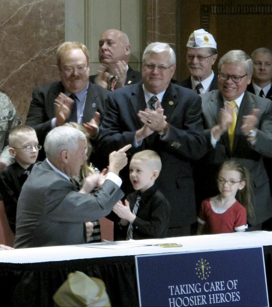 In this March 13, 2014 photo, Indiana Gov. Mike Pence, left, points to state Sen. Allen Paul, center, at an event at the Indiana War Memorial in Indianapolis where Pence signed a bill Paul sponsored that gave more military families access to the state&#39;s Military Family Relief Fund. Paul retired from the General Assembly in late 2014. The Indianapolis Star reports that a contract Paul later reached with the state&#39;s Department of Veterans Affairs may have violated state lobbying laws. (AP Photo/Rick Callahan)