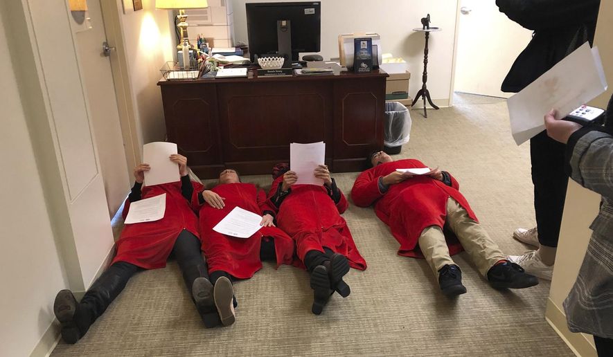 Advocates for the Equal Rights Amendment stage a "die in" outside Virginia House Speaker Kirk Cox's office at the Capitol in Richmond, Va. Thursday Feb. 14, 2019. Two of the women were taken away by Capitol Police. (AP Photo/Alan Suderman)