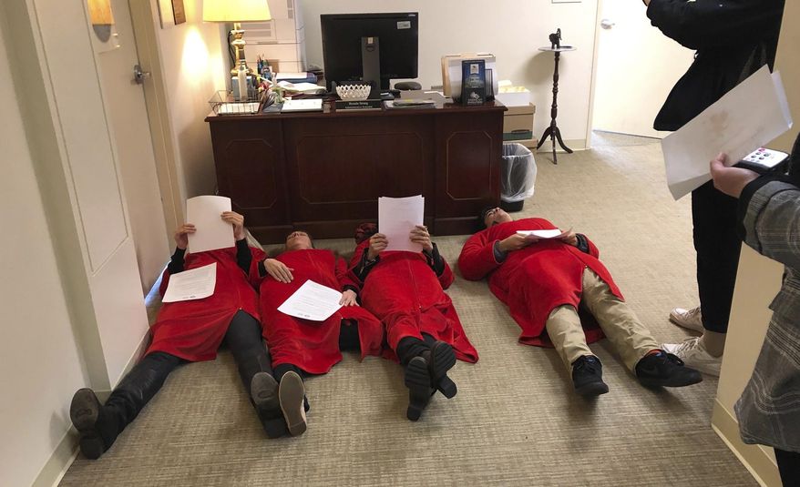 Advocates for the Equal Rights Amendment stage a "die in" outside Virginia House Speaker Kirk Cox's office at the Capitol in Richmond, Va. Thursday Feb. 14, 2019. Two of the women were taken away by Capitol Police. (AP Photo/Alan Suderman)
