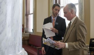 FILE - In this March 10, 2017 file photo, Rep. Zach Brown, D-Bozeman, left, speaks to fellow Rep. Jim Hamilton, D-Bozeman, after a session of the Montana Legislature in Helena, Mont. Rep. Brown is sponsoring a bill that would align state law with a U.S. Supreme Court ruling that found it unconstitutional to sentence most criminals under the age of 18 to life in prison without the possibility of parole, Friday, Feb. 15, 2019. (AP Photo/Bobby Caina Calvan, File)