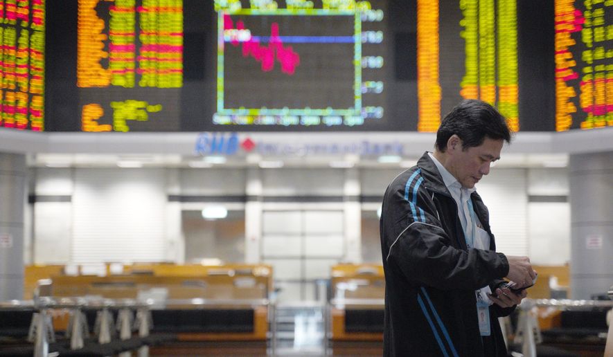An Investor stands in front of private stock trading boards at a private stock market gallery in Kuala Lumpur, Malaysia, Friday, Feb. 15, 2019. Asian shares are broadly lower, tracking a weak Wall Street session as traders await the conclusion of U.S.-China talks in Beijing. Japan's benchmark Nikkei 225 retreated 1.2 percent and the Kospi in South Korea gave up 1.6 percent on Friday. (AP Photo/Yam G-Jun)
