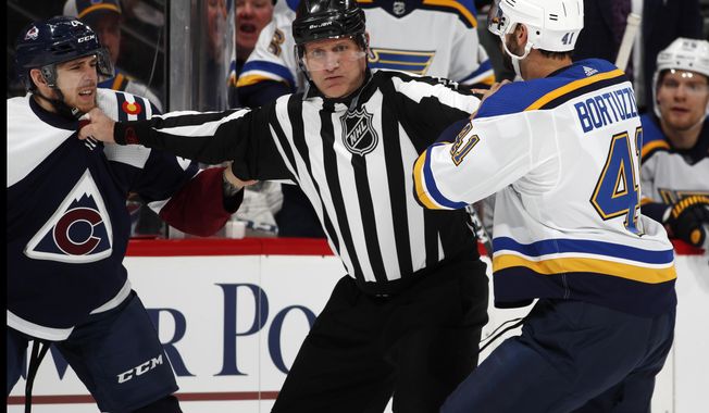 Linesman Greg Devorski, center, separates Colorado Avalanche left wing A.J. Greer, left, and St. Louis Blues defenseman Robert Bortuzzo as they try to fight in the first period of an NHL hockey game Saturday, Feb. 16, 2019, in Denver. Both players were assessed a penalty for their actions. (AP Photo/David Zalubowski)