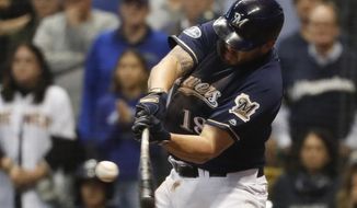 FILE - In this Oct. 5, 2018, file photo, Milwaukee Brewers&#39; Mike Moustakas hits an RBI single during the eighth inning of Game 2 of the National League Divisional Series baseball game against the Colorado Rockies in Milwaukee. A person familiar with the negotiations says Moustakas and the Brewers are nearing a deal that would keep the third baseman in Milwaukee for a guarantee of about $10 million. The person spoke to The Associated Press on condition of anonymity Sunday, Feb. 17, 2019, because the agreement will be subject to a successful physical. (AP Photo/Jeff Roberson, File)