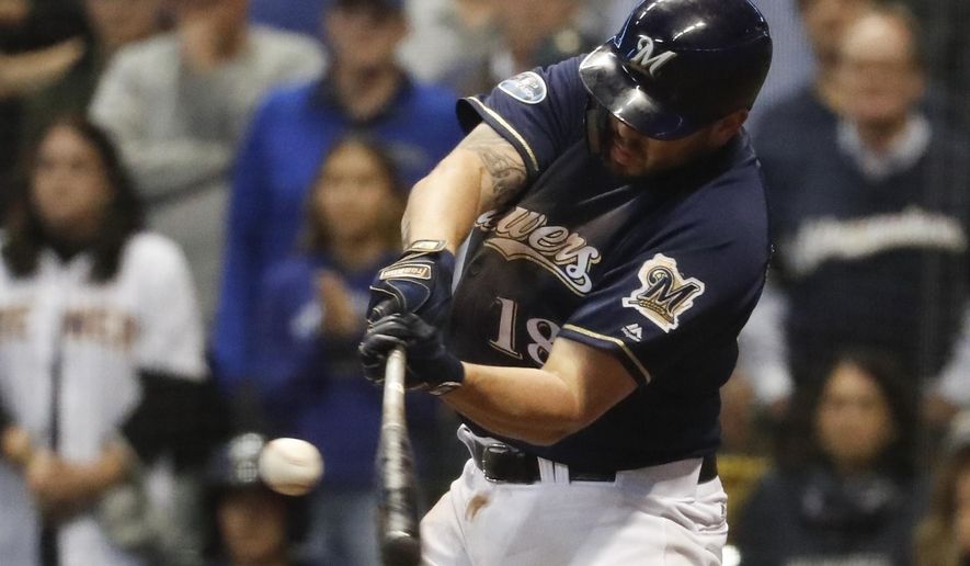 FILE - In this Oct. 5, 2018, file photo, Milwaukee Brewers' Mike Moustakas hits an RBI single during the eighth inning of Game 2 of the National League Divisional Series baseball game against the Colorado Rockies in Milwaukee. A person familiar with the negotiations says Moustakas and the Brewers are nearing a deal that would keep the third baseman in Milwaukee for a guarantee of about $10 million. The person spoke to The Associated Press on condition of anonymity Sunday, Feb. 17, 2019, because the agreement will be subject to a successful physical. (AP Photo/Jeff Roberson, File)