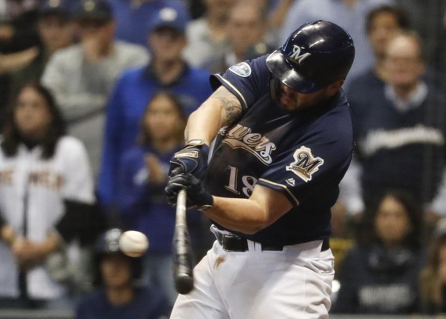 FILE - In this Oct. 5, 2018, file photo, Milwaukee Brewers' Mike Moustakas hits an RBI single during the eighth inning of Game 2 of the National League Divisional Series baseball game against the Colorado Rockies in Milwaukee. A person familiar with the negotiations says Moustakas and the Brewers are nearing a deal that would keep the third baseman in Milwaukee for a guarantee of about $10 million. The person spoke to The Associated Press on condition of anonymity Sunday, Feb. 17, 2019, because the agreement will be subject to a successful physical. (AP Photo/Jeff Roberson, File)