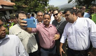 U.S. Senator Marco Rubio, R-Fla., in sunglasses, poses for photos with people near the Simon Bolivar International Bridge, which connects Colombia with Venezuela, in La Parada, near Cucuta, Colombia, Sunday, Feb. 17, 2019. As part of U.S. humanitarian aid to Venezuela, Rubio is visiting the area where the medical supplies, medicine and food aid is stored before it it expected to be taken across the border on Feb. 23. (AP Photo/Fernando Vergara)