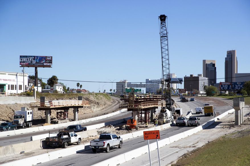 FILE- In this Dec. 21, 2018 photo, construction crews work on the new Harbor Bridge project on Interstate-37 in Corpus Christi, Texas. Construction on a $930 million project to replace a Corpus Christi bridge is behind schedule despite reaching a major milestone this month. The Corpus Christi Caller-Times reports that construction company Flatiron/Dragados recently acknowledged that the replacement of the 60-year-old Harbor Bridge likely won’t be complete by its April 2020 deadline. The first span of the bridge was put into place on the north side of the Corpus Christi Ship Channel this month. (Rachel Denny Clow/Corpus Christi Caller-Times via AP, File)