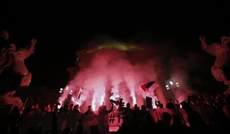 People light flares in front of the Serbian parliament building during a protest march against populist President Aleksandar Vucic in Belgrade, Serbia, Saturday, Feb. 16, 2019. People protested against what they say is Serbian President Aleksandar Vucic’s autocratic rule. (AP Photo/Darko Vojinovic)