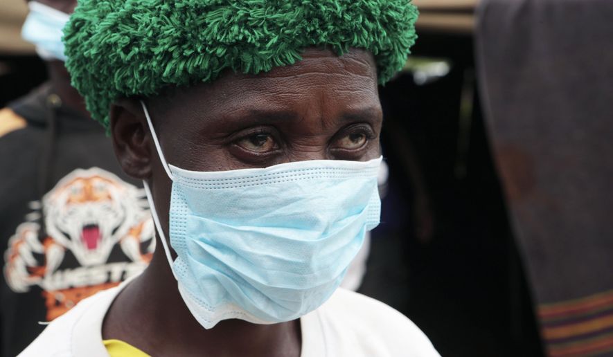 A woman emerges from a tent where bodies of the small-scale gold miners who were caught underground Tuesday are being identified, on the outskirts of Kadoma town about 200 kilometres west of Harare, Sunday, Feb. 17, 2019. Eight subsistence miners who were trapped underground for several days after heavy flooding in Zimbabwe were rescued on Saturday, though dozens of their co-workers are still missing and feared dead. (AP Photo/Tsvangirayi Mukwazhi)