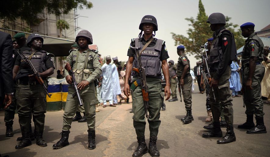 Nigerian police guard the entrance of the All Progressives Congress (APC) party headquarters where Incumbent President Muhammadu Buhari holds an emergency meeting with senior members of the party in Abuja, Nigeria, Monday Feb. 18, 2019. Nigeria's electoral commission delayed the presidential election until Feb. 23. (AP Photo/Jerome Delay)