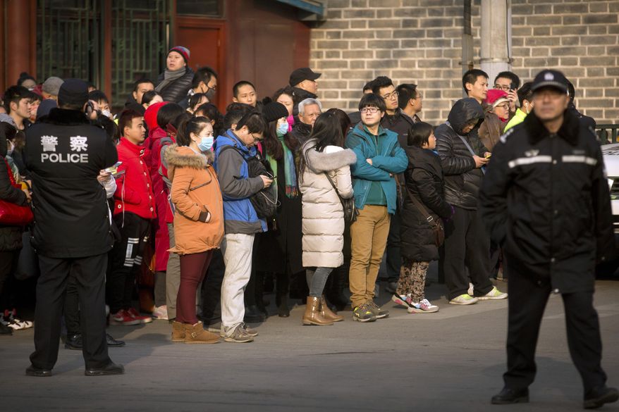 FILE - In this Jan. 1, 2016, file photo, Chinese policemen watch as depositors from Ezubao gather outside the State Bureau for Letters and Calls Reception Division office in Beijing. China's policy ministry says it investigated 380 online lenders and froze $1.5 billion in assets in a crackdown following an avalanche of scandals in the huge but lightly regulated industry. The ministry said Monday, Jan. 18, 2019, it launched the investigation in June because the industry was increasingly risky and rife with complaints about fraud, mismanagement and waste. (AP Photo/Mark Schiefelbein, File)