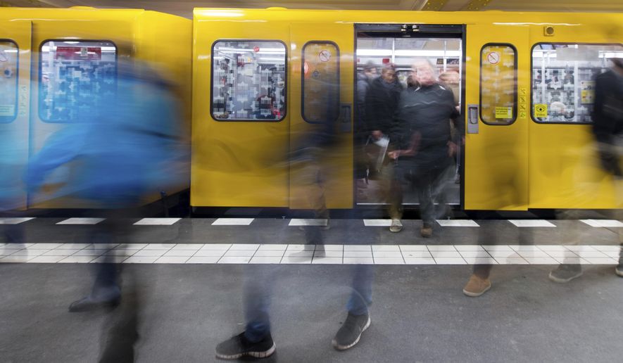 File -- In this Friday, Feb. 20, 2015 photo travellers leave a BVG subway train in Berlin, Germany. Berlin is unveiling a new app that will let people use public transport, rental bikes, car-sharing and taxis seamlessly to travel through the German capital. (Lukas Schulze/dpa via AP)