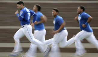 Kansas City Royals&#39; Jordan Romano, left, leads teammates as they run sprints during baseball spring training Friday, Feb. 15, 2019, in Surprise, Ariz. (AP Photo/Charlie Riedel)