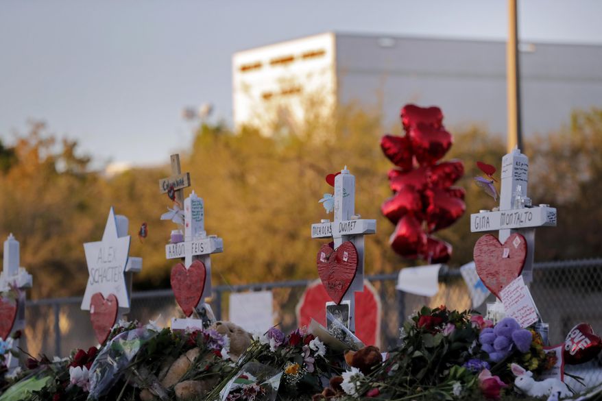 In this Feb. 19, 2018, file photo a makeshift memorial is seen outside the Marjory Stoneman Douglas High School, where 17 students and faculty were killed in a mass shooting in Parkland, Fla. There have been more than 415 incidents of gunfire on U.S. school grounds since 2013, according to Every Town for Gun Safety, a nonprofit aimed at reducing domestic gun violence. Last year’s carnage at Marjory Stoneman Douglas High School surpassed the 1999 Columbine High School massacre as the deadliest high school shooting in U.S. history. (AP Photo/Gerald Herbert, File)
