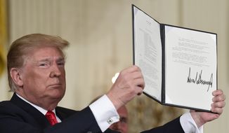 In this June 18, 2018, photo, President Donald Trump holds up the space policy directive that he signed during a National Space Council meeting in the East Room of the White House in Washington.  Trump is moving closer toward his goal of creating a Space Force, but it won&#39;t begin as a separate military branch as the president envisioned. The Space Force instead initially will be created as part of the Air Force, but could be spun into a separate military department in the future. That&#39;s according to senior administration officials who briefed journalists on a directive Trump is scheduled to sign Tuesday to establish the Space Force. (AP Photo/Susan Walsh) **FILE**