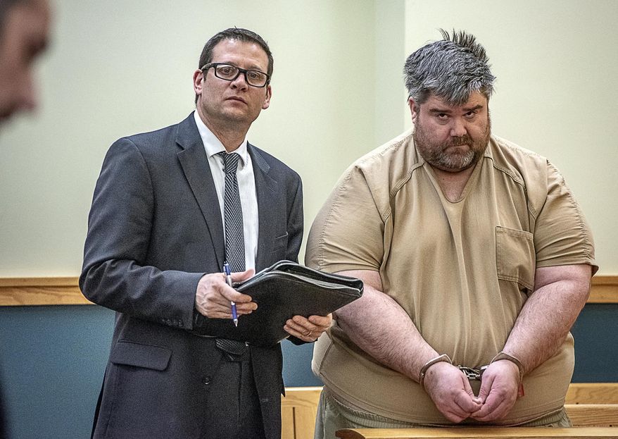 Steven Downs, 44, of Auburn, Maine, right, stands for his initial appearance in 8th District Court in Lewiston, Maine, on Tuesday, Feb. 19, 2019. Downs has been charged with the 1993 rape and murder of 20-year-old Sophie Sergie at the University of Alaska Fairbanks. Standing with Downs is Attorney Richard Charest. (Andree Kehn/Sun Journal via AP)