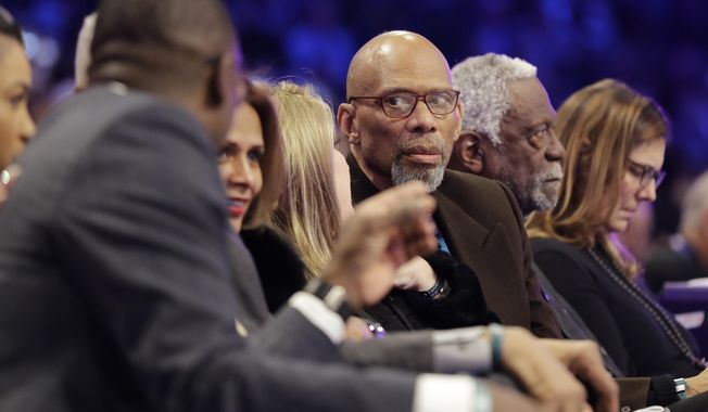Former NBA player Kareem Abdul-Jabbar, center, speaks with Dominque Wilkins, left, as former player Bill Russell is seen at right, during the NBA All-Star skills session basketball contest, Saturday, Feb. 16, 2019, in Charlotte, N.C. (AP Photo/Chuck Burton)