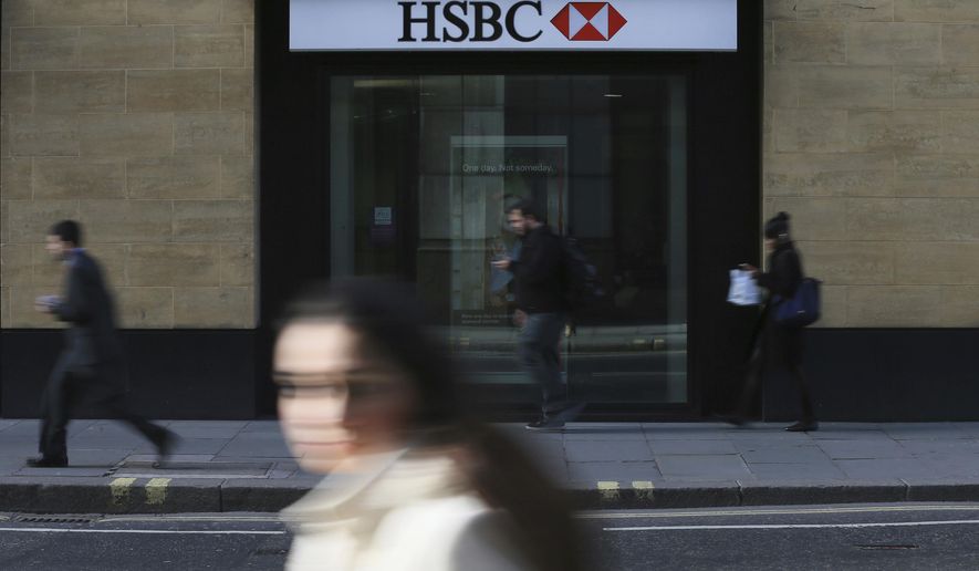 FILE - In this Nov. 2, 2015, file photo, a person walks past a branch of HSBC near Liverpool Street Station in London. Europe’s biggest bank has reported its net profit jumped 30 percent in 2018 from the previous year to $12.6 billion. (AP Photo/Tim Ireland, File)
