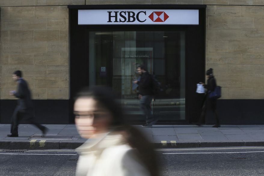 FILE - In this Nov. 2, 2015, file photo, a person walks past a branch of HSBC near Liverpool Street Station in London. Europe’s biggest bank has reported its net profit jumped 30 percent in 2018 from the previous year to $12.6 billion. (AP Photo/Tim Ireland, File)