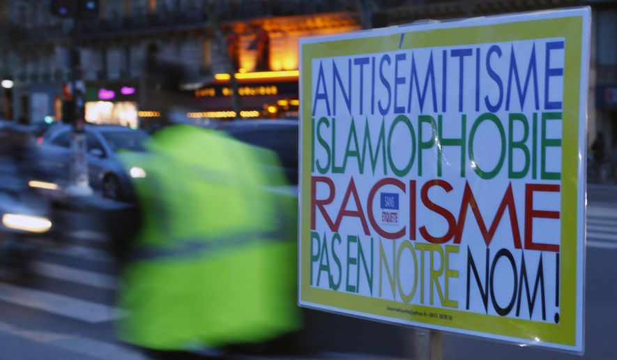 A poster reading &amp;quot;Anti-Semitism, Islamophobia, Racism, Not in Our Name&amp;quot; during a gathering decrying anti-Semitism at Place de la Republique in Paris, Monday, Feb. 18, 2019 amid an upsurge in anti-Semitism in France. It reached a climax last weekend with a torrent of hate speech directed at a distinguished philosopher during a march of yellow vest protesters, adding to questions about the radicalized fringes of the movement hidden within French society and troubling the nation. (AP Photo/Francois Mori)
