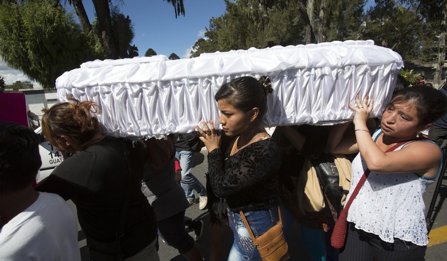 FILE - In this March 10, 2017 file photo, women carry the coffin of 17-year-old Siona Hernandez Garcia, a girl who died in a March 8, 2016 fire at the Virgin of the Assumption Safe Home, at the cemetery in Guatemala City. On Tuesday, Feb. 19, 2019, a Guatemalan judge ordered five current and ex-officials to stand trial over the blaze that killed 41 girls and injured 15 others at the state-run home for troubled youth. (AP Photo/Moises Castillo, File)